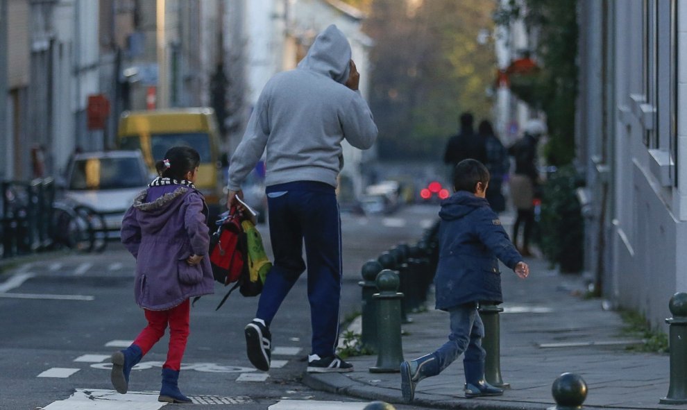 Un padre regresa a casa con sus hijos después de descubrir que la escuela está cerrada en Bruselas (Bélgica). EFE/Laurent Dubrule