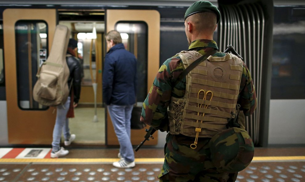 Efectivos militares vigilan la estación central del metro en Bruselas. REUTERS/Pasajeros entrando al metro en Bruselas. REUTERS/Benoit Tessier