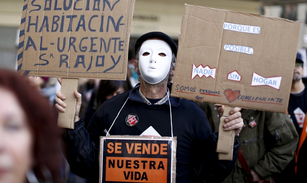 Un manifestante sujeta pancartas en la protesta convocada por la plataforma "Nadie sin Hogar" defendiendo el derecho a la vivienda en el centro de Madrid, España, 26 de noviembre de economía 2015. REUTERS / Paul Hanna