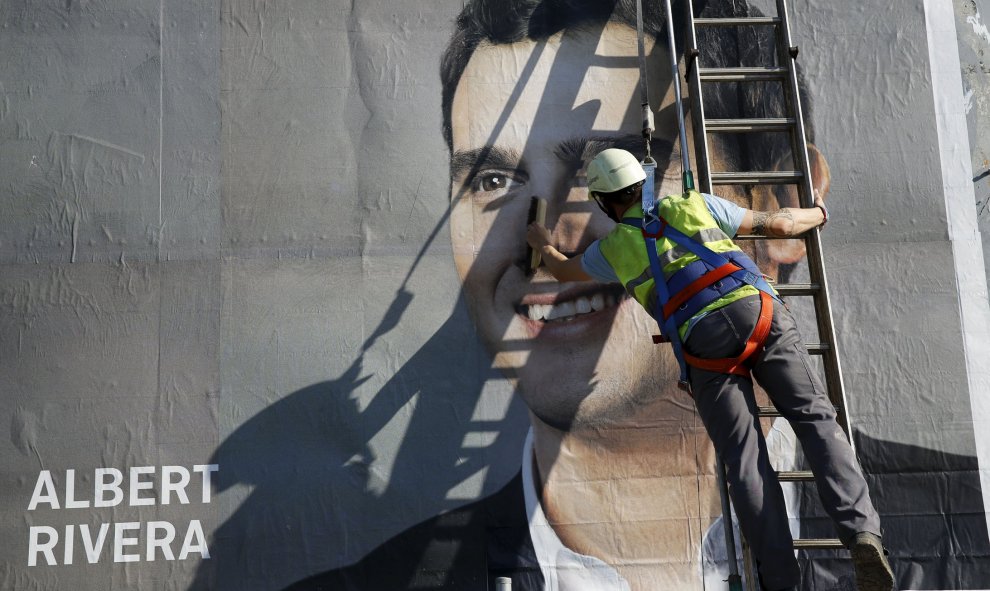 Un operario termina de colocar un cartel de Albert Rivera. REUTERS/Marcelo del Pozo