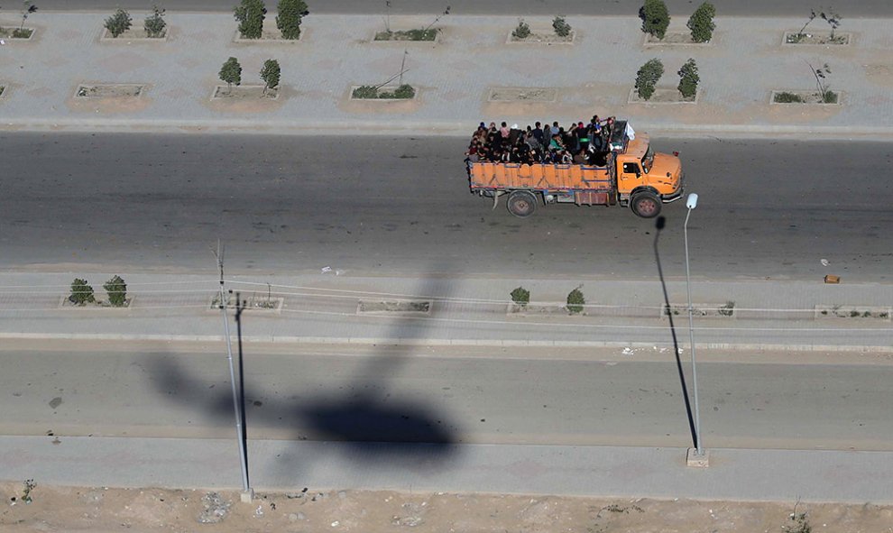 Una fotografía aérea muestra la sombra de un helicóptero de las fuerzas de seguridad iraquíes, mientras un camión transporta peregrinos musulmanes chiítas, en la ciudad de Kerbala, a unos 120 kilómetros de Bagdad.- MOHAMMED SAWAF (AFP)