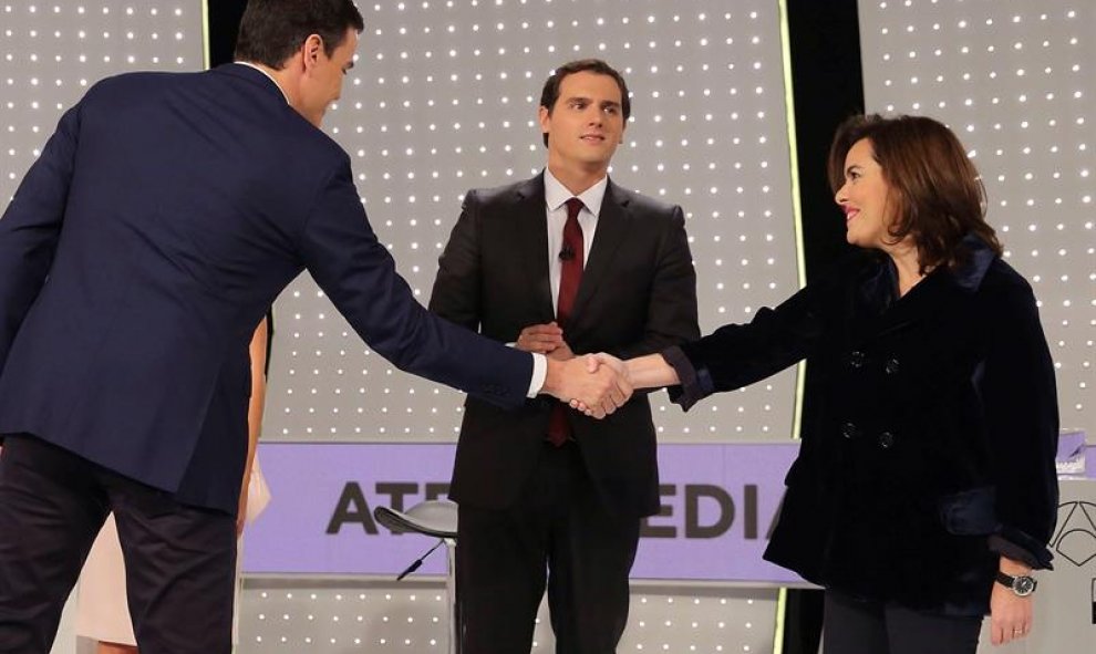 El secretario general del PSOE, Pedro Sánchez (i) saluda a la vicepresidenta del Gobierno y candidata por Madrid al Congreso, Soraya Sáenz de Santamaría, en presencia del presidente de Ciudadanos, Albert Rivera (c) antes del debate televisivo entre los ca