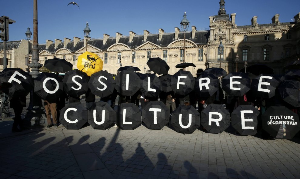 Activistas protestan frente a la pirámide del Louvre en París para pedir al museo que cancele sus contratos con la petrolera francesa Total y la italiana Eni. REUTERS/Benoit Tessier