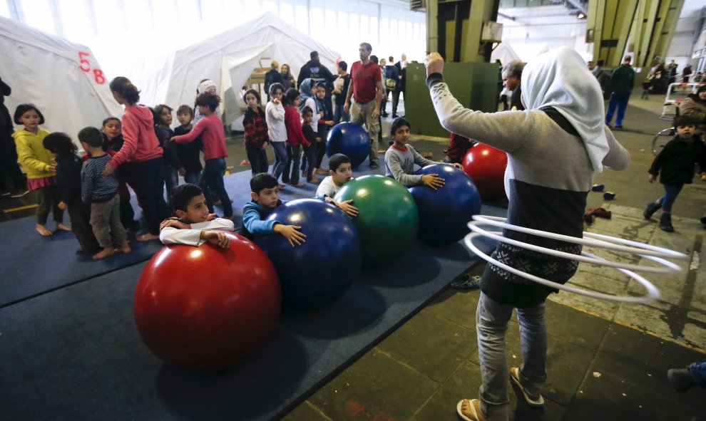Niños juegan en un refugio para inmigrantes dentro de un hangar del antiguo aeropuerto de Tempelhof, en Berlín. REUTERS/Fabrizio Bensch