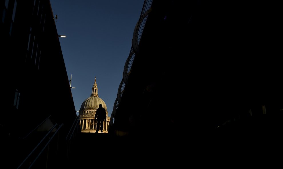 Un trabajador camina cerca de la catedral de St Paul's en Londres./ REUTERS