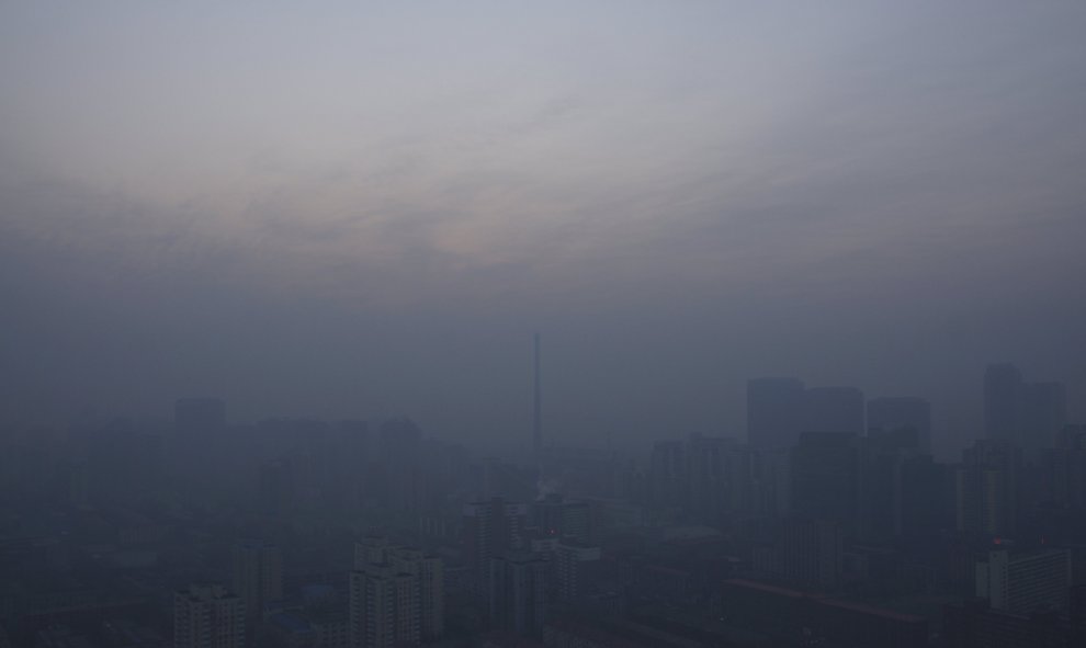 La ciudad perdida de Pekín, oculta tras una espesa niebla de polución, en una imagen tomada a plena luz del día. La capital china anunció la primera alerta roja de su historia, desde que este sistema de cuatro colores (rojo, naranja, amarillo y azul) fue