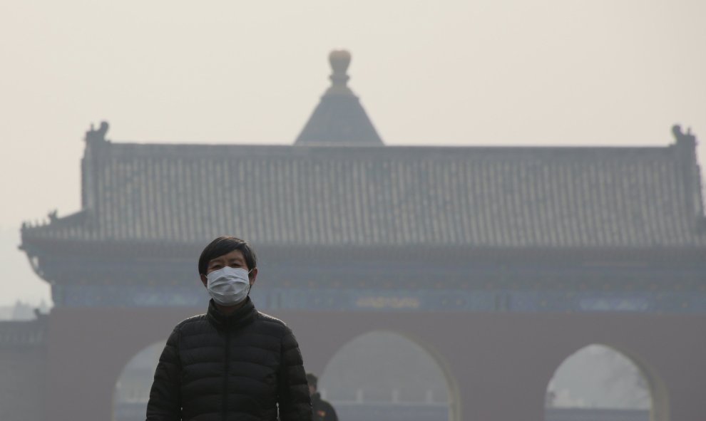 Una persona camina frente a uno de los monumentos de la ciudad perdida de Pekín, oculta tras una espesa niebla de polución. LLa concentración de contaminación al mediodía en Pekín (04.00 GMT) se situaba en unos 180 microgramos por metro cúbico de partícul