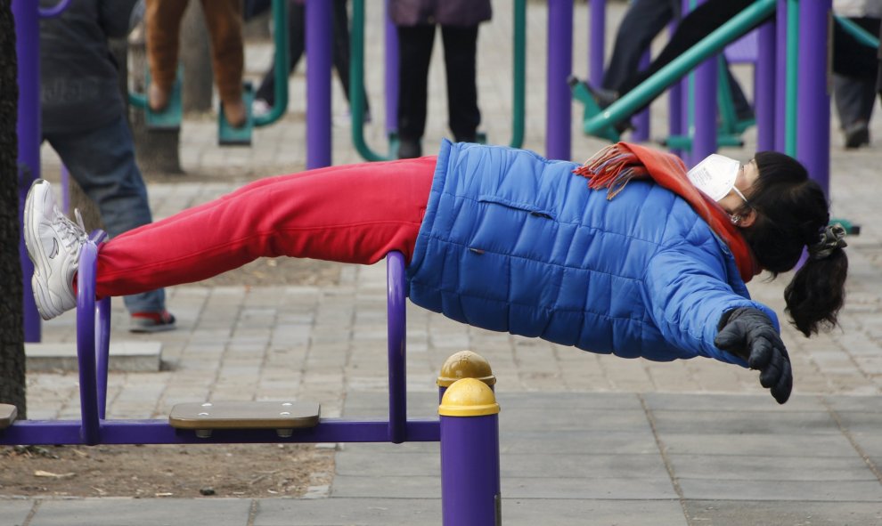 Una niña juega en un parque infantil de Pekín. Pese a estar muy por encima de los 25 microgramos recomendados por la Organización Mundial de la Salud (OMS), no llega a los 200 que las autoridades estipulan para decretar la alerta roja cuando la concentrac