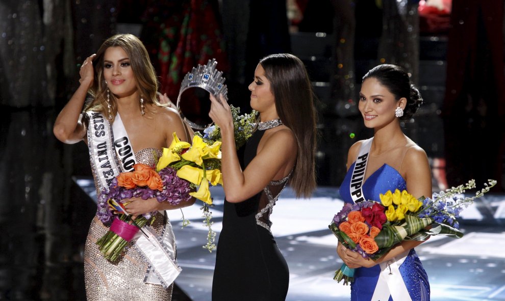 Paulina Vegas le quita la corona a la Miss Colombia Ariadna Gutiérrez (izq) a la que habían nombrado ganadora por error, para dárselo a la Miss Filipinas Pia Alonzo Wurtzbach (drcha) durante el Miss Universo 2015 en Las Vegas, Nevada, anoche. REUTERS / St