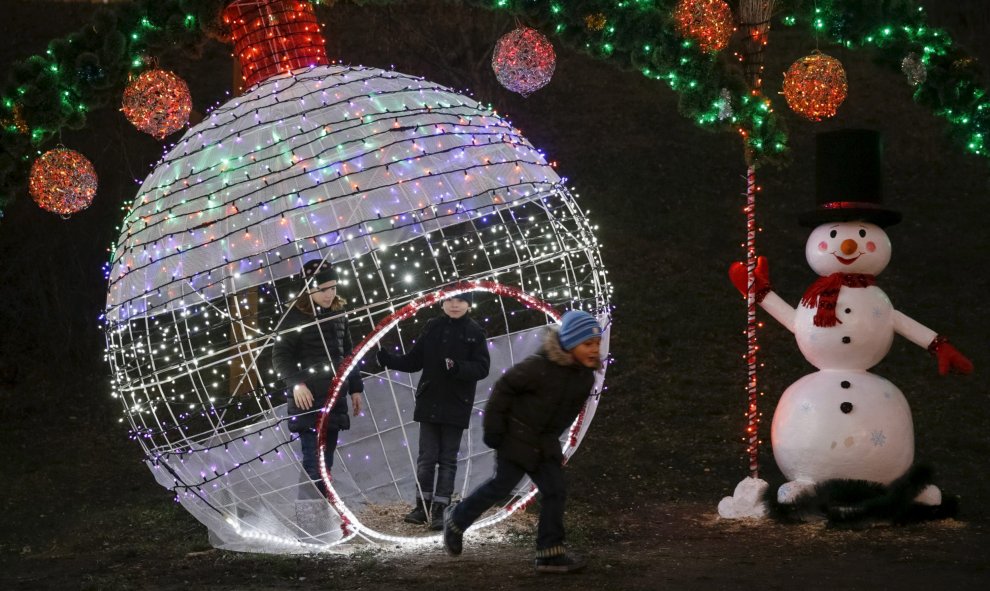 Varios niños juegan en un parque que está decorado con luces de navidad, en Kiev, Ucrania. REUTERS / Valentyn Ogirenko