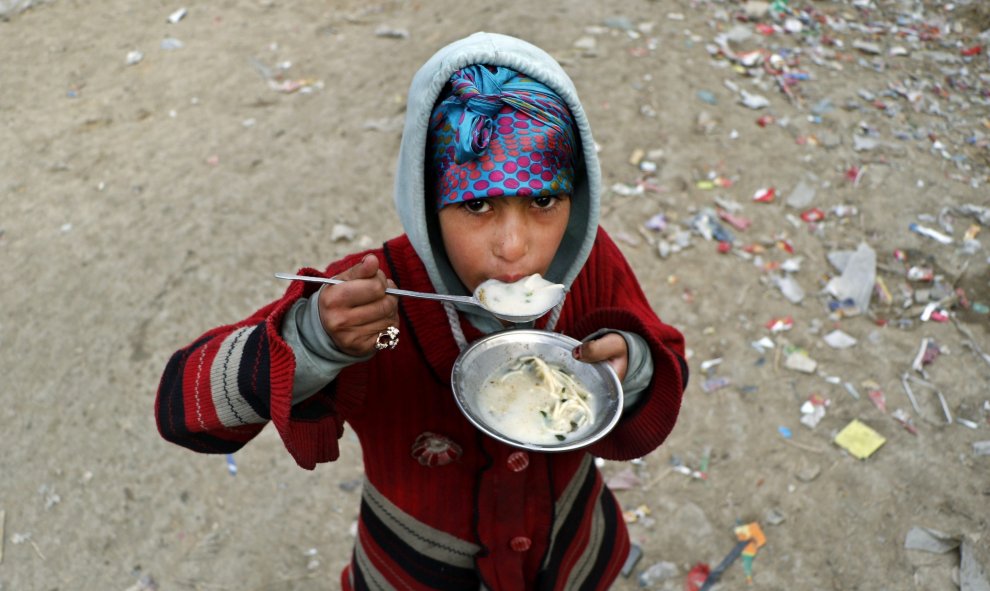 Una niña come en el campo de desplazados internos (IDP) de Kabul, Afganistán, hoy 21 de diciembre 2015. La crisis de los refugiados afganos es la más larga jamás registrada en la historia de ACNUR, dado que 36 años después de las primeros huidos, aún hoy