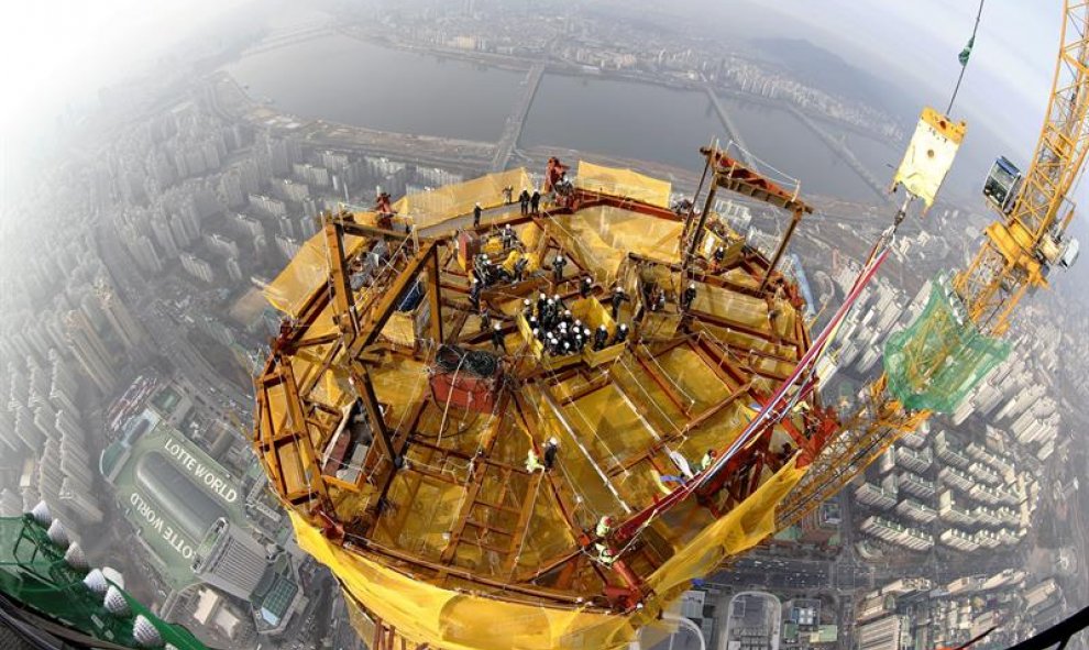 Operarios surcoreanos permanecen en la planta 123 del rascacielos Lotte World Tower durante la fase de finalización de las obras. EFE/JEON HEON-KYUN