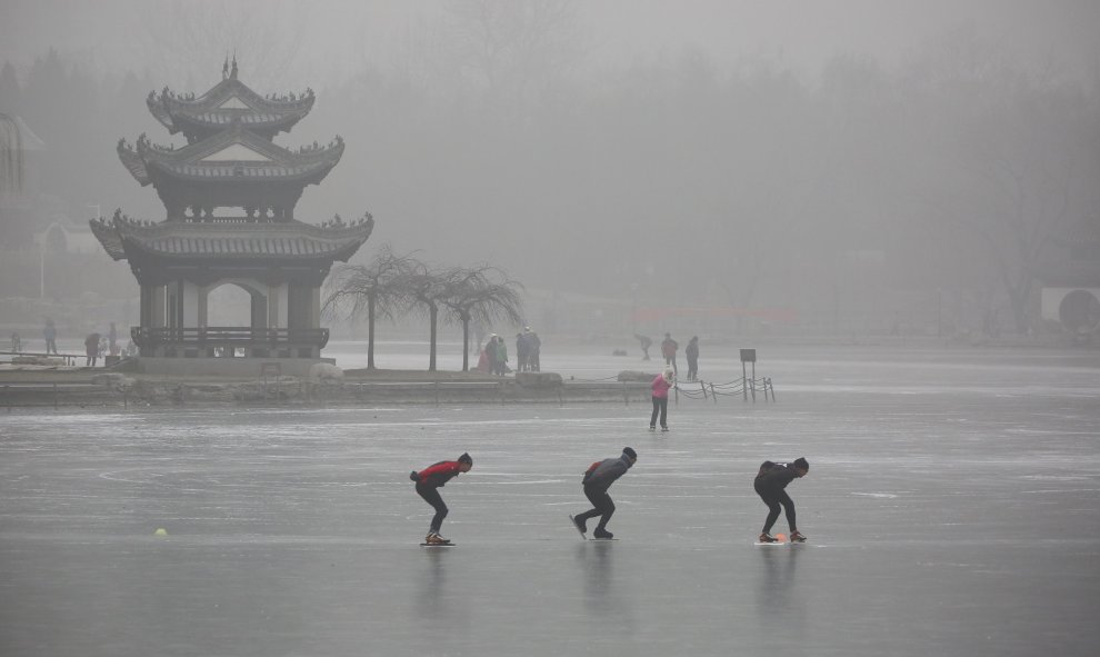 Personas patinan en un lago congelado en el Parque Taoranting durante un día brumoso, en Pekín, China. REUTERS / Stringer,