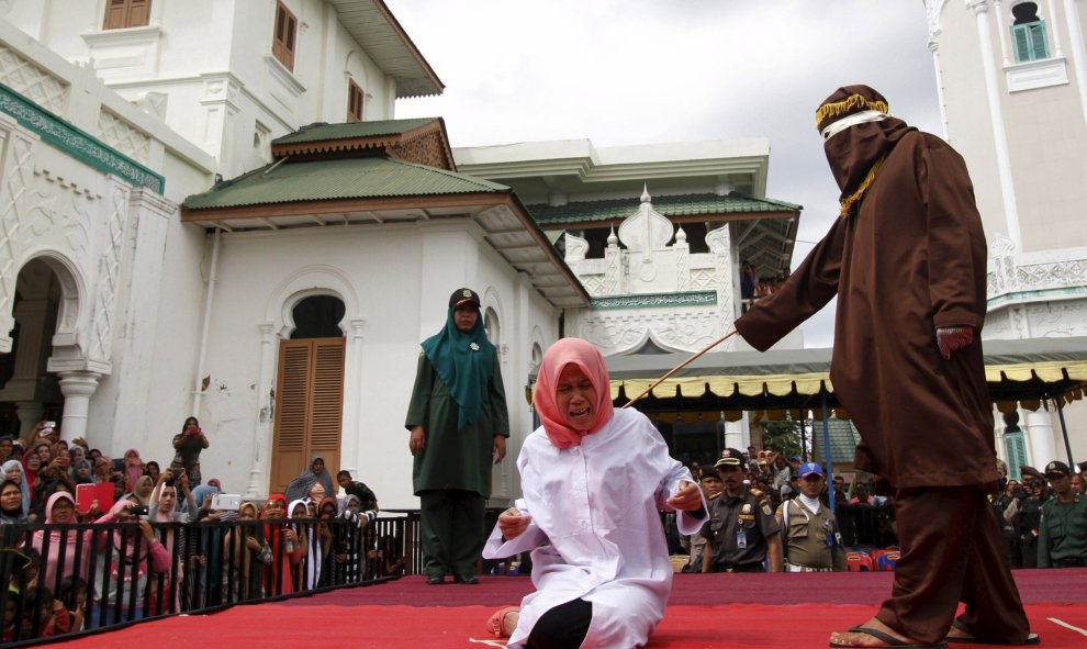 Nur Elita, grita mientras la golpean en el patio de la mezquita Baiturrahman en Banda Aceh, la provincia indonesia de Aceh 28 de diciembre de 2015. Nur Elita recibió cinco golpes de vara por tener relaciones sexuales antes del matrimonio con su novio, seg