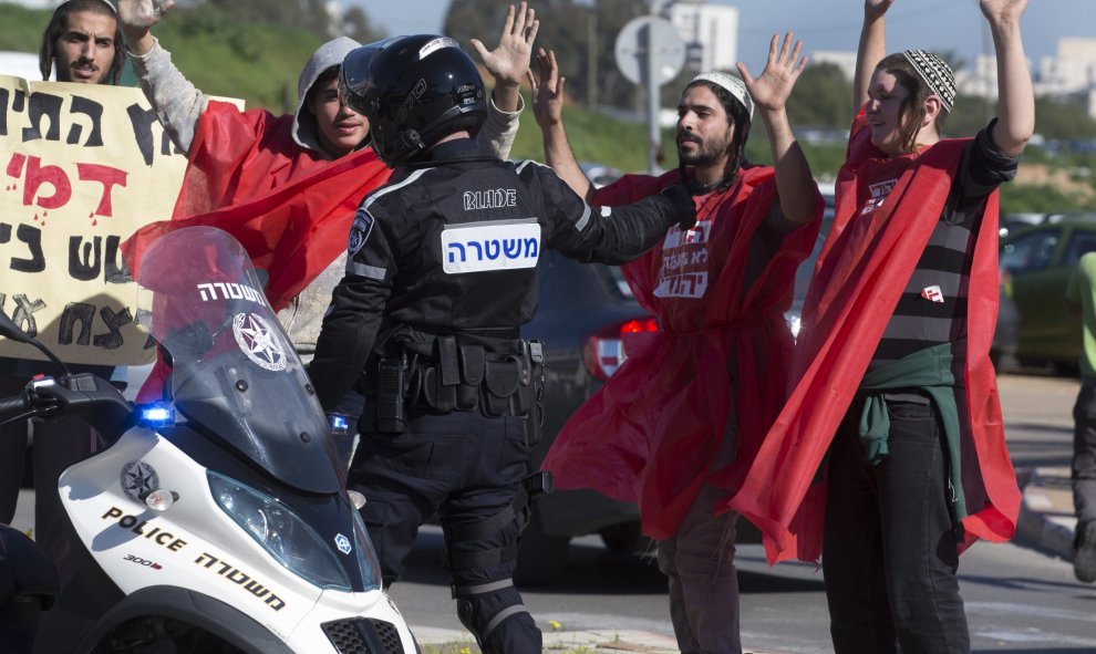 Un grupo de judíos colonos de derechas levanta sus manos ante las órdenes de la policía durante una protesta en las afueras del juzgado de paz en Petah Tikvav, cerca de Tel Aviv, Israel, hoy 28 de diciembre 2015.  EFE/Jim Hollander