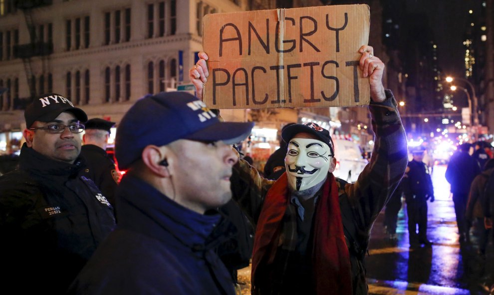 Un manifestante muestra una pancarta que dice "Pacifista enfadado", en las protestas contra la decisión de un jurado de Ohio de no juzgar al policía que mató a un menor afroamericano. REUTERS/Eduardo Munoz.