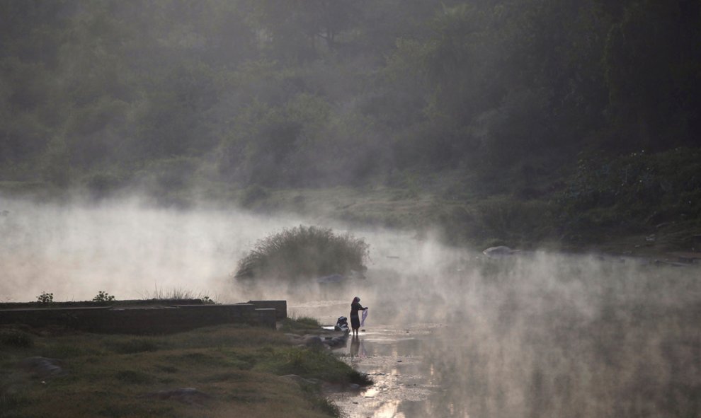 Una mujer lava la ropa en el río Cauvery, en la India. REUTERS/Abhishek N. Chinnappa