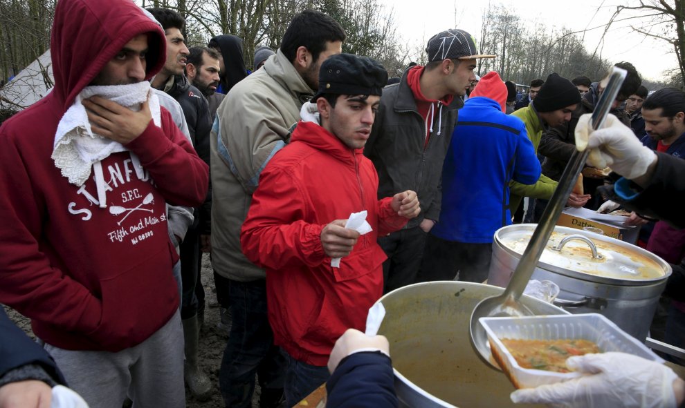 Los inmigrantes hacen cola para la comida en un campamento provisional para refugiados de procedentes de Irak, Kurdistán, Irán y Siria, cerca de Dunkerque (Francia). REUTERS / Pascal Rossignol