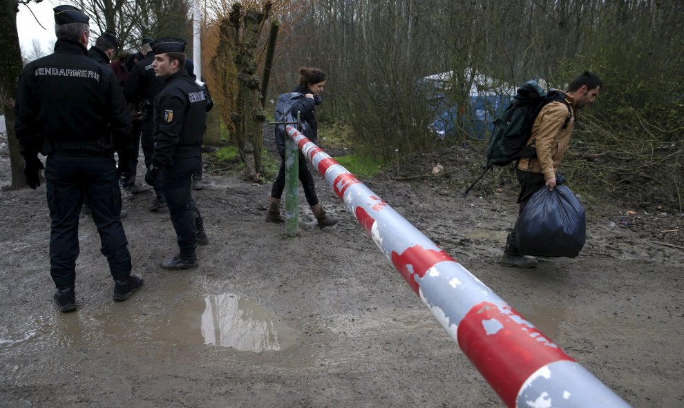 Los gendarmes franceses controlan la entrada de inmigrantes en el campamento provisional para refugiados de procedentes de Irak, Kurdistán, Irán y Siria, cerca de Dunkerque (Francia). REUTERS / Pascal Rossignol