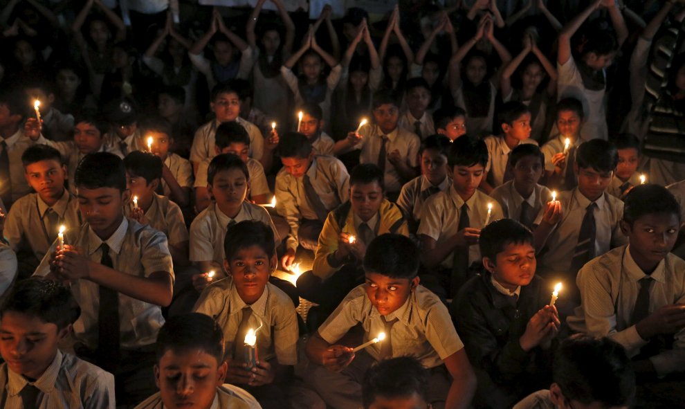 Estudiantes sostienen velas mientras participan en una ceremonia por las víctimas de un ataque a la base aérea Pathankot, en una escuela en Ahmedabad. REUTERS/Amit Dave