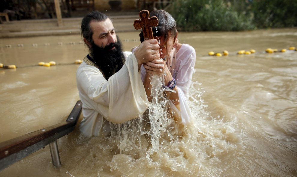 Un padre bautiza a su hijo en el Río Jordán. REUTERS/Nir Elias