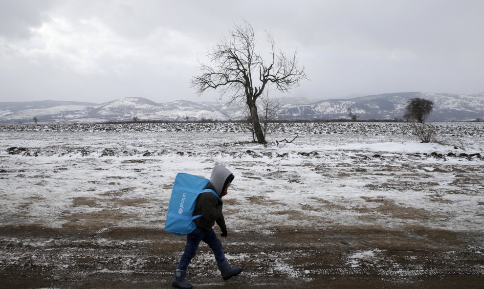 Un niño refugiado camina a través del campo cubiero de nieva hacia Macedonia. Cerca del pueblo de Miratovac, Serbia. REUTERS/Marko Djurica