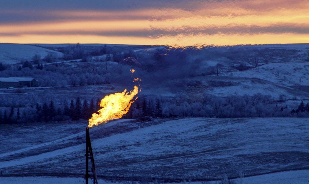 Una llamarada de gas natural en una plataforma del pozo de petróleo arde durante la puesta de sol en Watford City, Dakota del Norte. REUTERS/Andrew Cullen