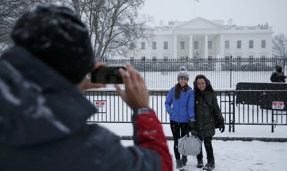 Unos turistas se fotografian frente a la Casa Blanca, llena de nieve. /REUTERS