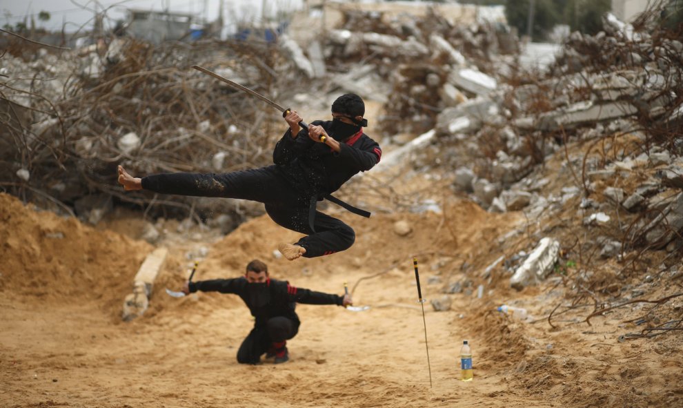 Jóvenes palestinos salta con una espada al estilo del ninja en el norte de la Franja de Gaza. REUTERS/Mohammed Salem