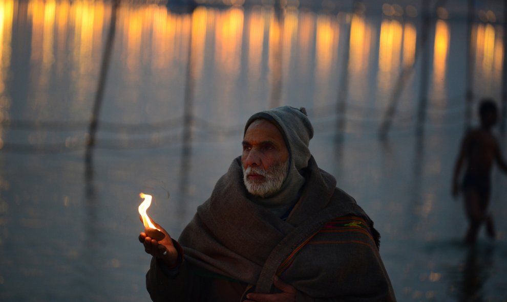 Un devoto hindú realiza oraciones en Sangam, la confluencia de los ríos Ganges, Yamuna y Saraswati durante el festival anual de Magh Mela en Allahabad el 4 de febrero de 2016. AFP/SANJAY Kanojia