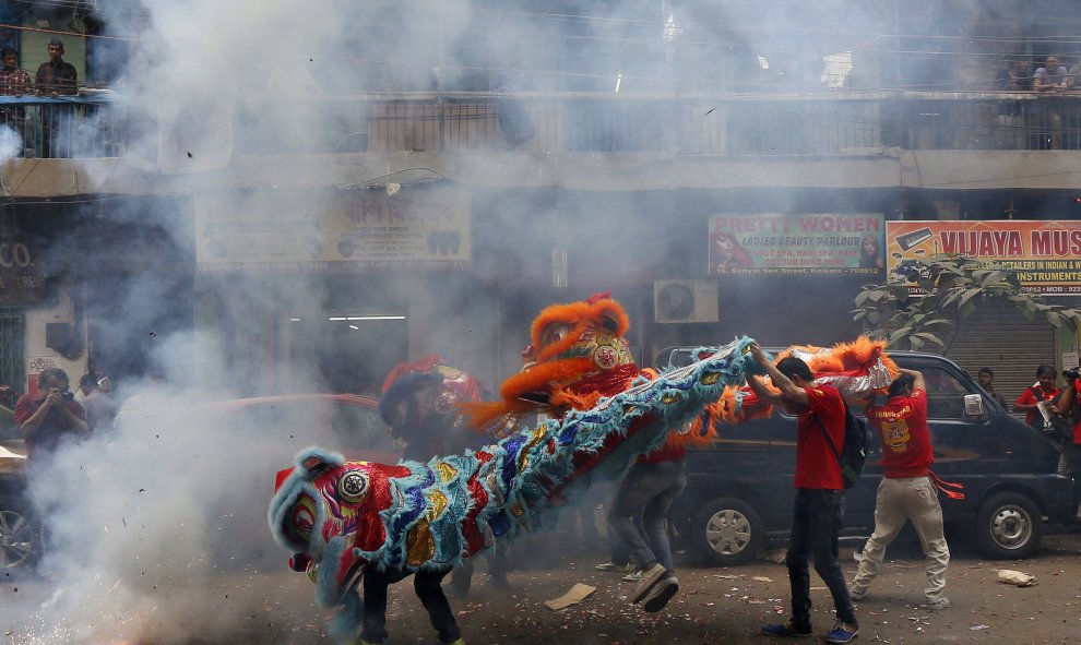 Miembros de la comunidad china actúan en medio de los cohetes en las celebraciones del Año Nuevo Chino de Calcuta, India. REUTERS/Rupak De Chowdhuri