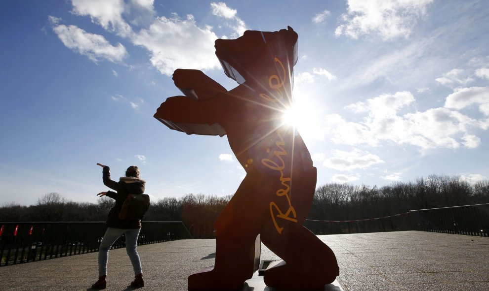 Una mujer se encuentra al lado del logotipo del próximo 66º Festival Internacional de Cine Berlinale en Berlín, Alemania, 10 de febrero de 2016. REUTERS / Fabrizio Bensch