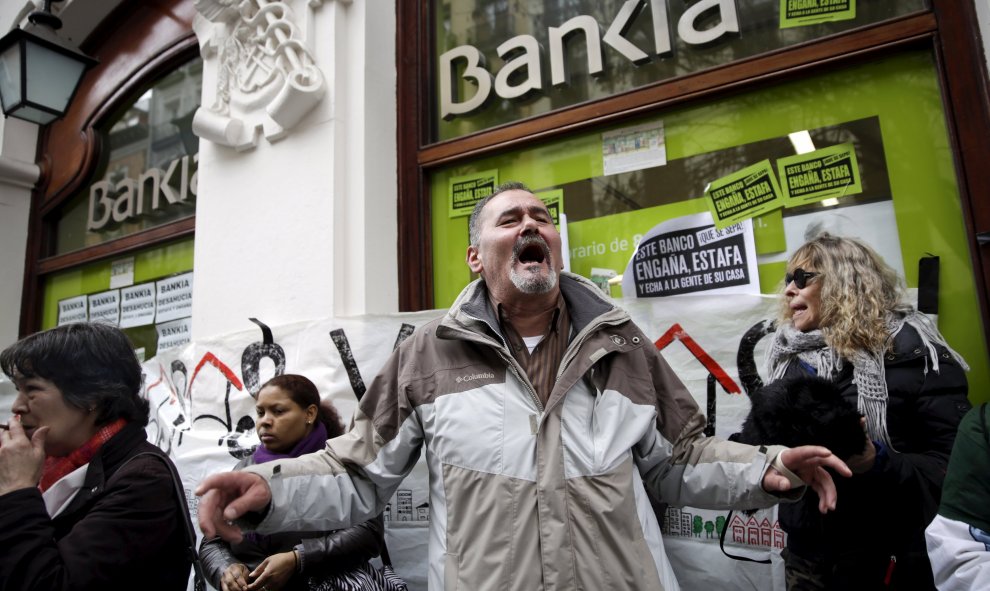 Activistas gritan durante una protesta contra los desahucios en una sucursal bancaria de Bankia en Madrid. REUTERS/Andrea Comas