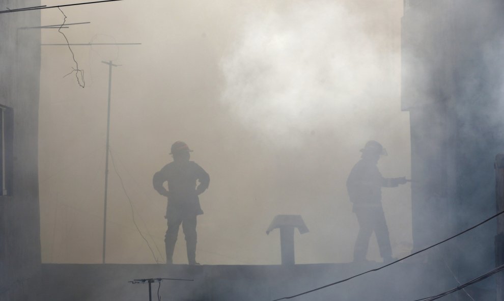 Bomberos filipinos trabajan en la extinción de un incendio en Manila, Filipinas. EFE/Mark R. Cristino