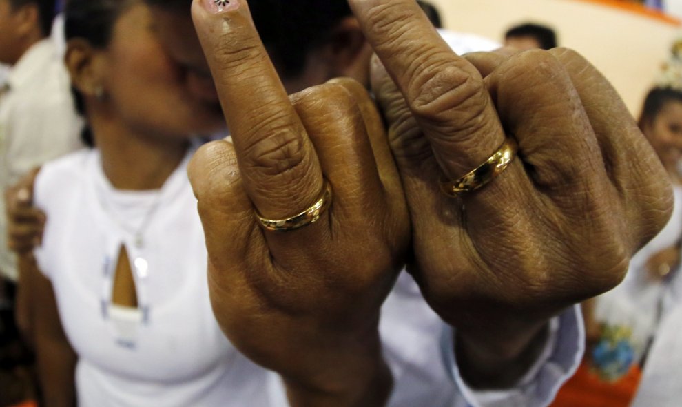 Una pareja de filipinos muestra sus anillos durante una boda masiva en Manila, Filipinas. EFE/FRANCIS R. MALASIG