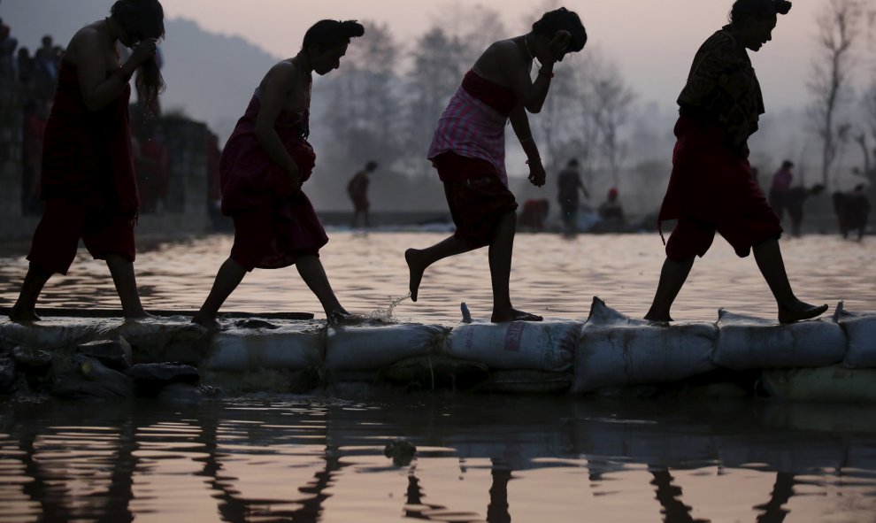 Devotos regresan después de tomar un baño sagrado en el río durante el festival Triveny Swasthani Brata Katha en Panauti, Nepal. REUTERS/Navesh Chitrakar