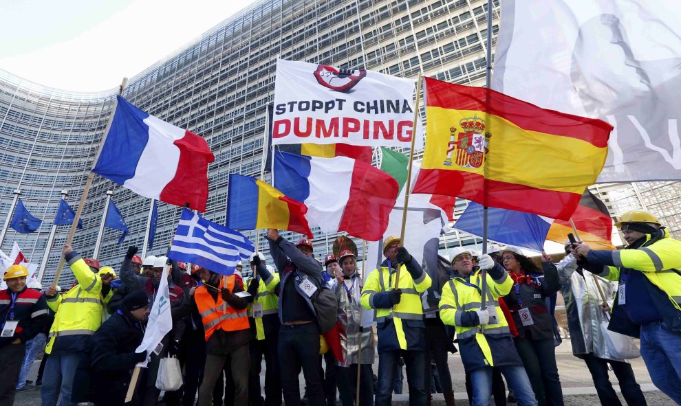 Los trabajadores europeos de acero sostienen banderas nacionales a medida que toman parte en una manifestación en el centro de Bruselas como protesta contra el dumping chino. REUTERS