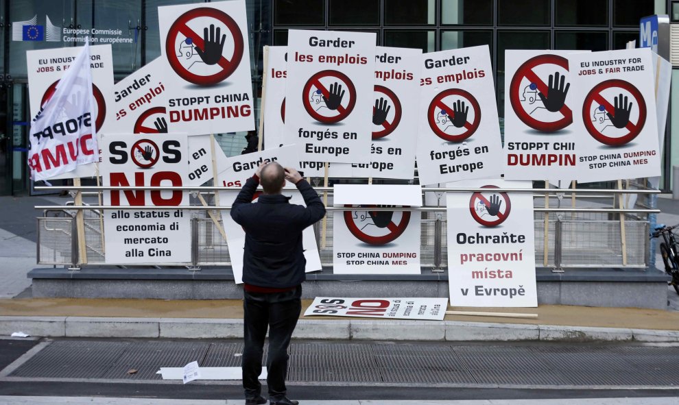 Un manifestante toma imágenes de los carteles que los trabajadores europeos de acero utilizan como protesta en el centro de Bruselas. REUTERS