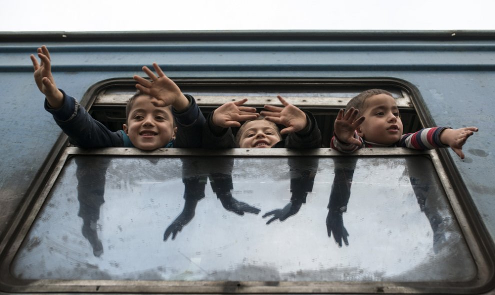 Niños estiran sus brazos mientras esperan a otros refugiados en un tren con destino a Serbia desde la frontera entre Macedonia y Grecia cerca de Gevgelija. Robert ATANASOVSKI/AFP