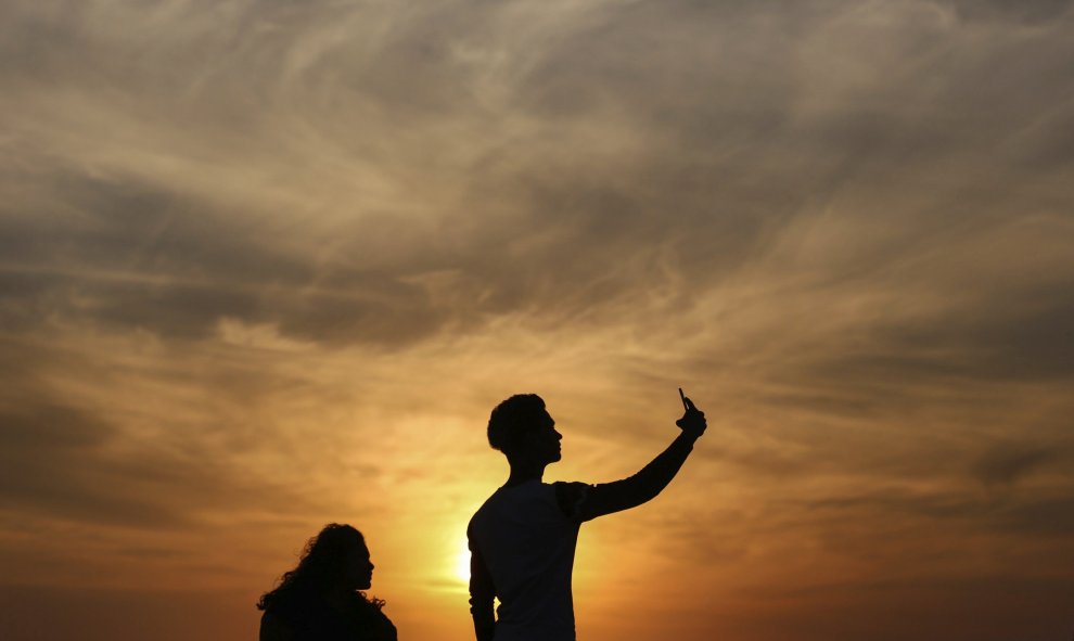 Varias personas se hacen un selfie en el paseo marítimo de Bandra Fort Band Stand junto al mar arábigo en Bombay, India. EFE/Divyakant Solanki