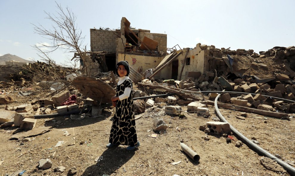 Una niña camina junto a su casa destruida en un ataque aéreo de la coalición liderada por Arabia Saudí en Saná, Yemen. EFE/Yahya Arhab