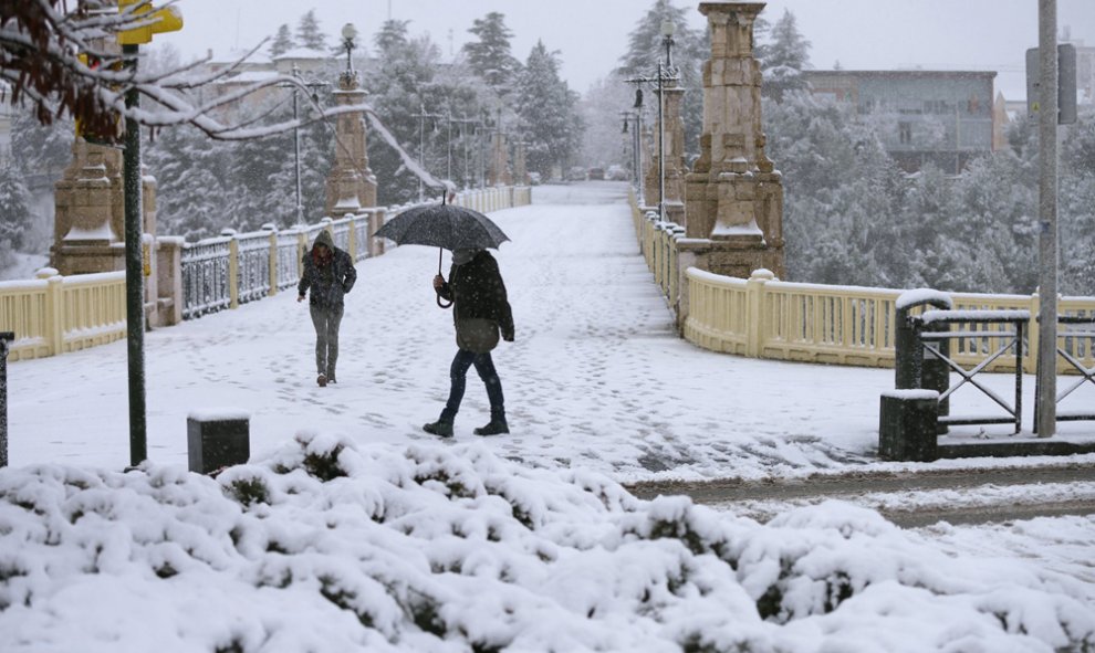 Dos personas caminan por una calle de Teruel, que hoy presentaba este aspecto debido a la nevada caída durante la pasada madrugada. EFE/Antonio García