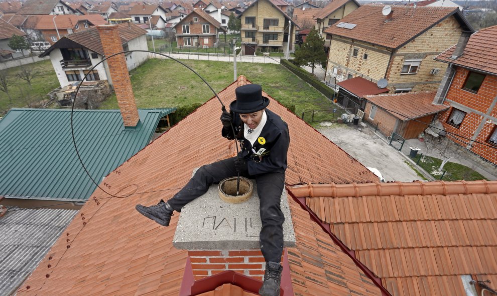 Dajana Djuric, que ha trabajado como un deshollinador desde los seis años, limpia una chimenea en Brcko, en Bosnia Herzegovina. REUTERS/Dado Ruvic