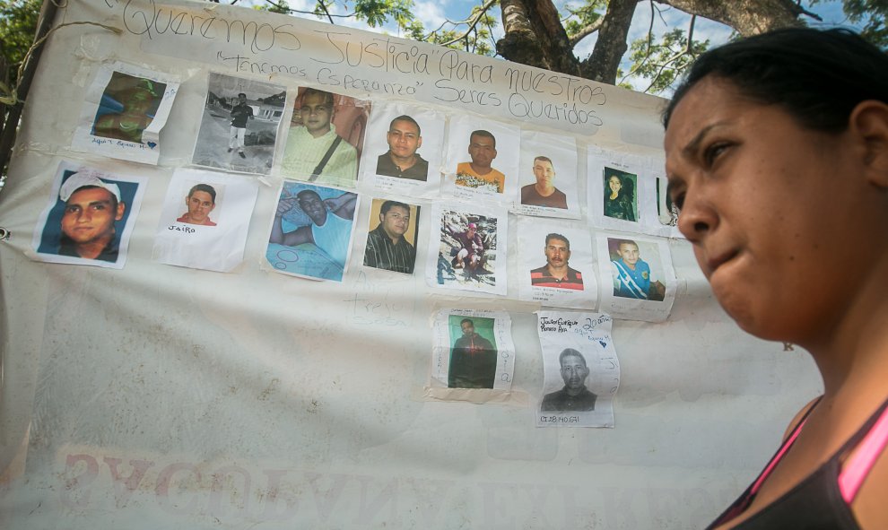 Una mujer camina junto a un cartel con fotografías de los mineros desaparecidos, hoy, miércoles 9 de marzo de 2016, en la localidad de Tumeremo, en el estado Bolivar, Venezuela. EFE/STR