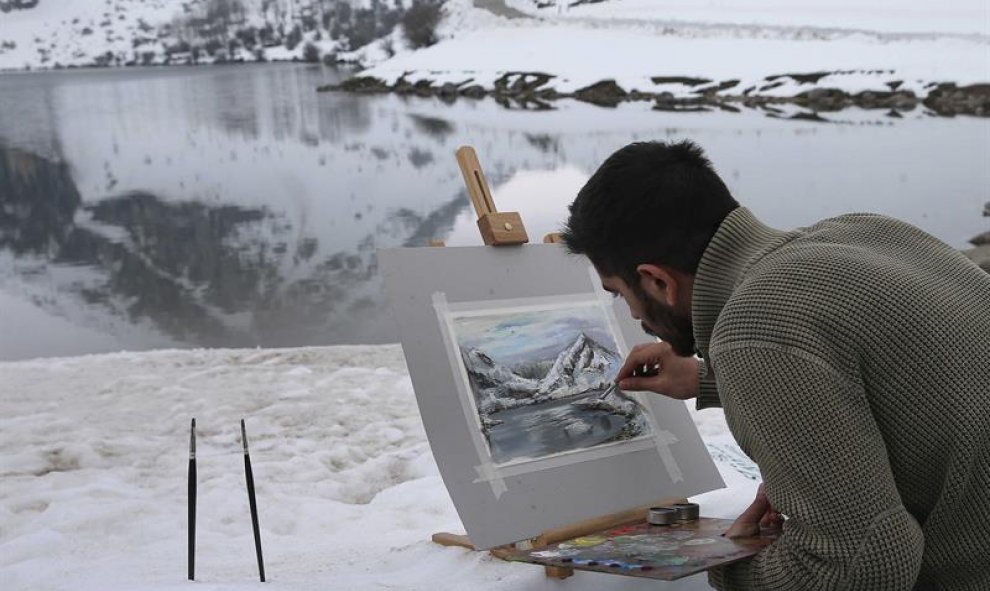 Un joven retrata los lagos de Covadonga, en el Parque Nacional de Picos de Europa. EFE/José Luis Cereijido