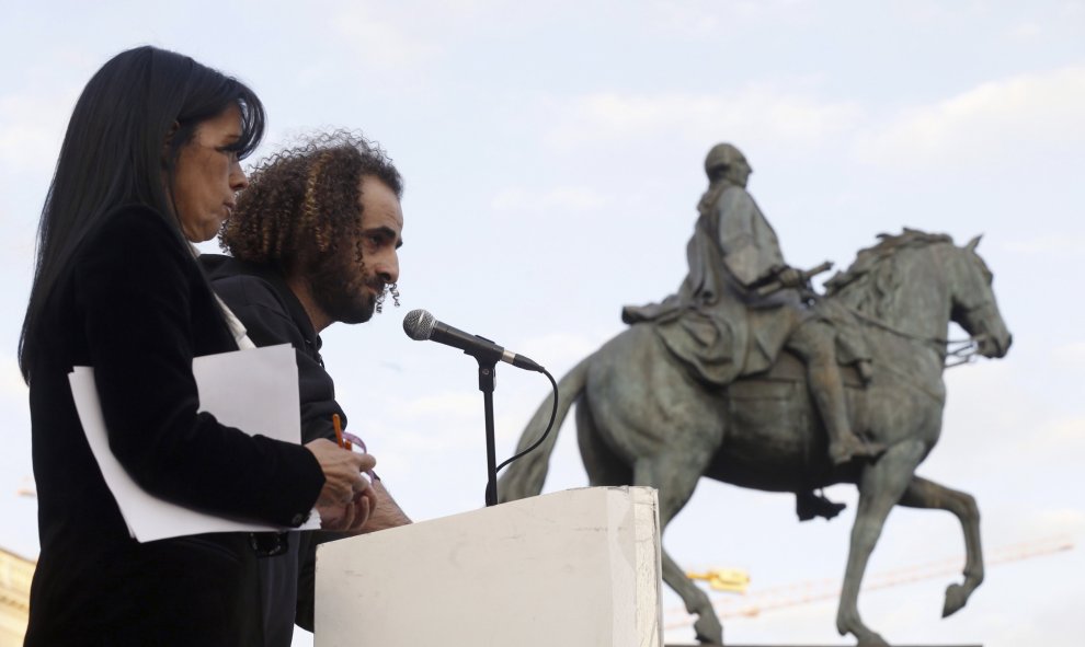 La cantante, Cristina del Valle, y el refugiado de Afganistan, Ahmed, leen el manifiesto durante la concentración de Madrid, que se ha sumado hoy al resto de ciudades españolas en su rechazo al acuerdo Unión Europea-Turquia sobre los refugiados, albergan