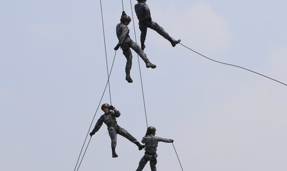 Reclutas de la Guardia Costera de Filipinas (PCG) descienden de un helicóptero durante un entrenamiento en el interior de la sede PCG en el puerto al sur de Manila. REUTERS/Romeo Ranoco