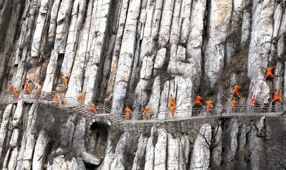 Estudiantes de una escuela de artes marciales de Shaolin Kung Fu practican en los acantilados en Dengfeng, provincia de Henan, China, 17 de marzo de 2016. REUTERS / Stringer