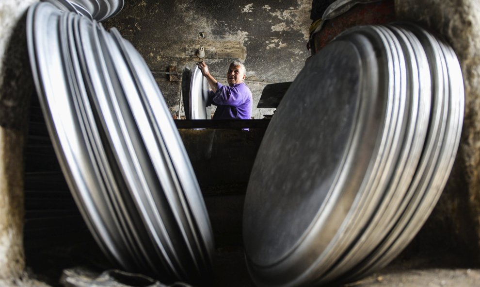 Un operario trabaja en el proceso de secado de piezas de menaje de cocina de aluminio en un taller de Mit Ghamr, Dakahlia, a 80 km al noreste de El Cairo (Egipto)./EFE/Mohammed Hossam