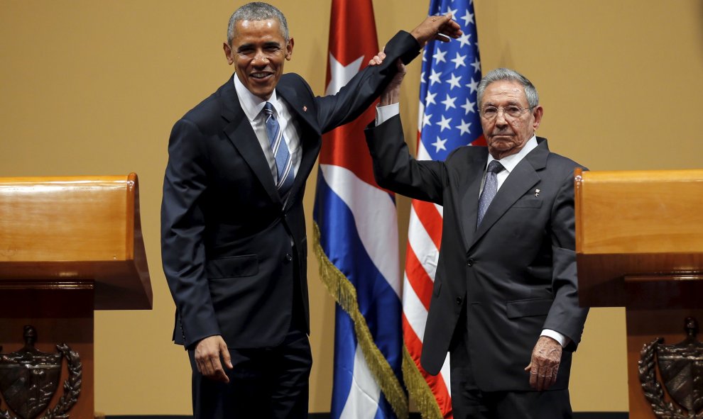 El presidente de Cuba, Raúl Castro, levanta el brazo de Obama tras la conferencia de prensa en el Palacio de la Revolución, en La Habana.- REUTERS